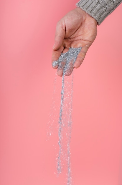 Free photo cute silver glitter falling from hand