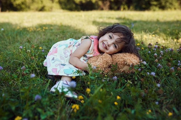 Free photo cute smiling baby girl hugging soft bear toy