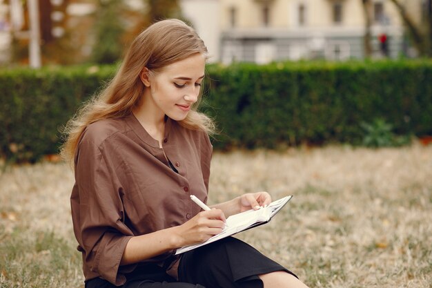 Cute student working in a park and use the notebook