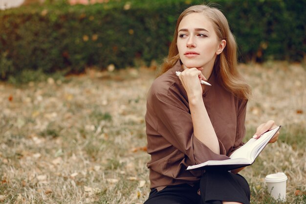 Cute student working in a park and use the notebook