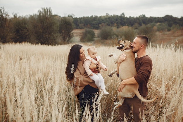 Cute and stylish family playing in a autumn field