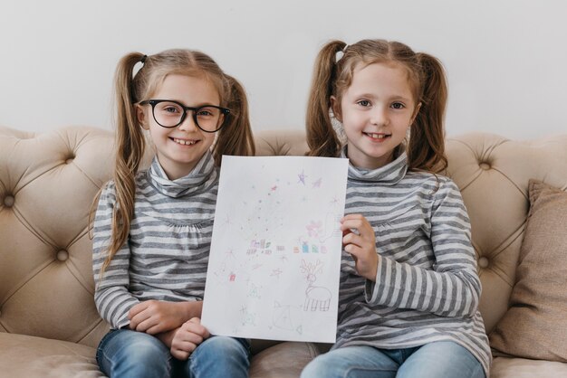 Cute twins holding a drawing