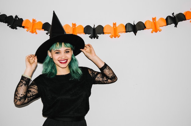 Cute witch holding her hat