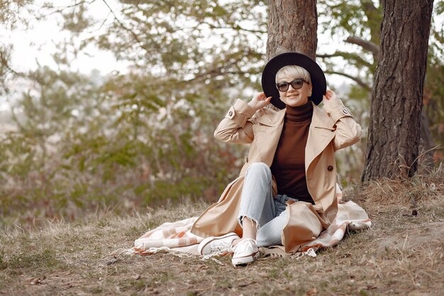 Cute woman have a rest in a autumn park