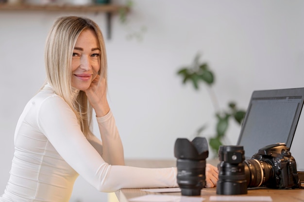 Cute woman at her workspace and camera lens