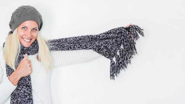 Free photo cute woman wrapping in knitted scarf