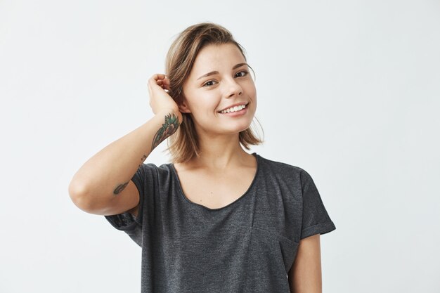 Cute young beautiful girl smiling correcting hair .