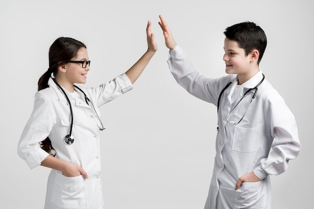 Cute young boy and girl dressed up as doctors