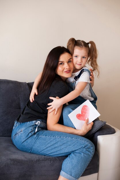 Cute young girl hugging her beautiful mother