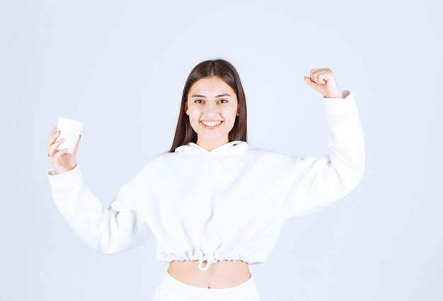 cute young girl model holding a plastic cup.