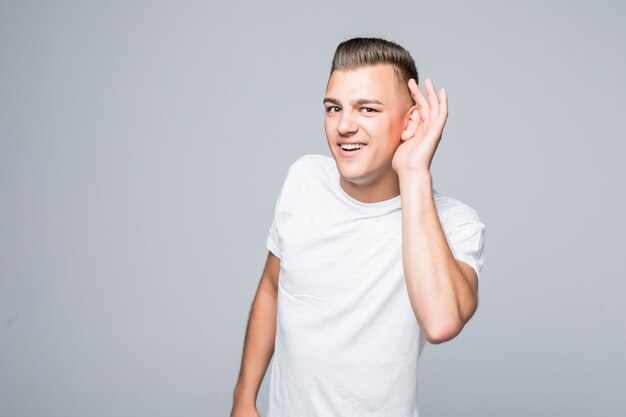 Cute young man boy shows do not hear you sign isolated on white wall