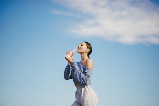 Cute young woman drinking water