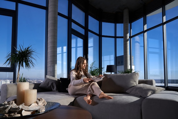 Free photo cute young woman reading book on sofa