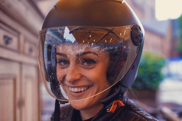 Cute young woman wearing a moto helmet.