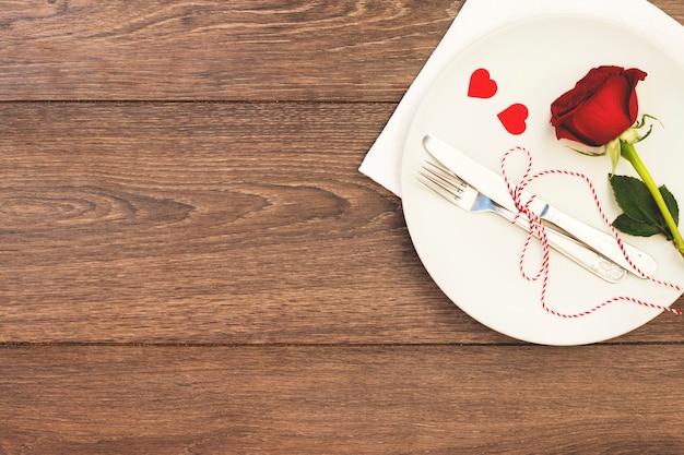 Cutlery with flower on dish above napkin