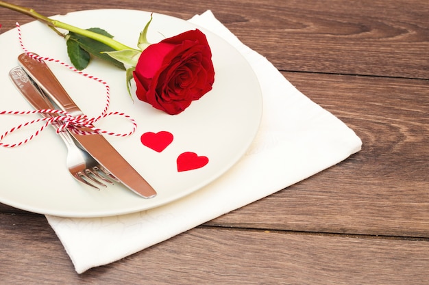 Cutlery with flower on plate above napkin