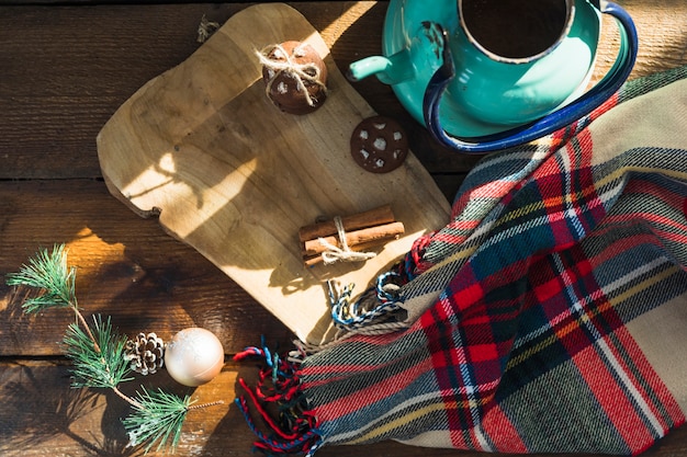 Free photo cutting board with biscuits near scarf and kettle