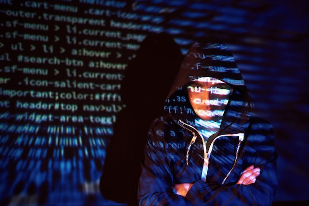 Free photo cyber attack with unrecognizable hooded hacker using virtual reality, digital glitch effect