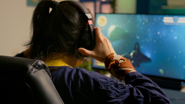 Free Photo cyber gamer playing space shooter video game using rgb keyboard and professional headset during gaming tournament. player talking with multiple players using headphones while streaming video games