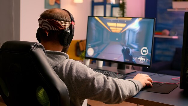 Cyber gamer stretching hands and neck before playing online video games using RGB keyboard and mouse. Player performing online games during gaming tournament