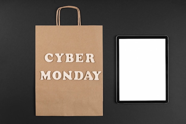 Free Photo cyber monday paper bag with an empty screen tablet