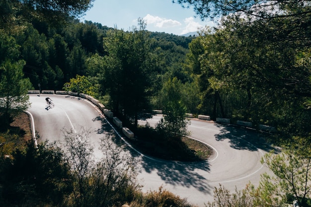 Free Photo cyclist riding a bike at sunset in a mountain road