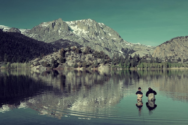 Dad fishing with son in lake in Yosemite.