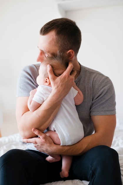 Dad hugging baby softly and carefully