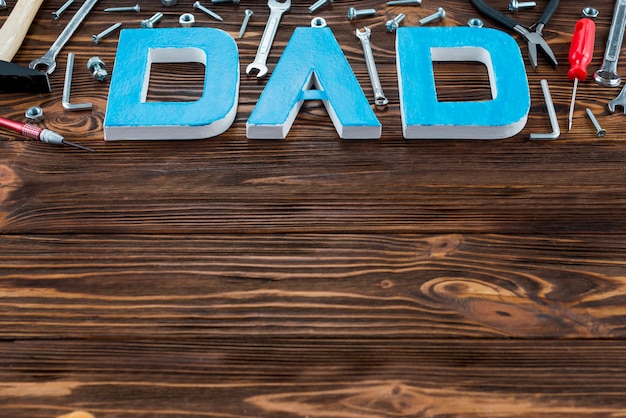 Dad inscription with different tools on wooden table