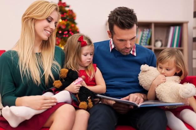 Free photo dad reading book for his daughters in christmas