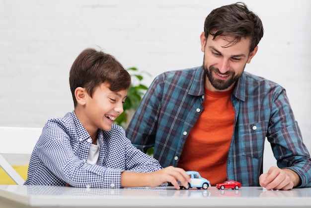 Free photo dad and son playing with toy cars