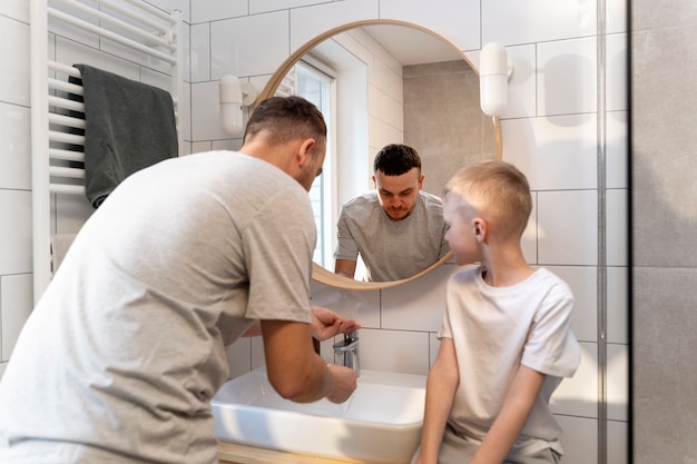 Dad teaching his son how to shave