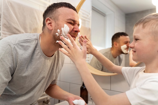 Dad teaching his son how to shave