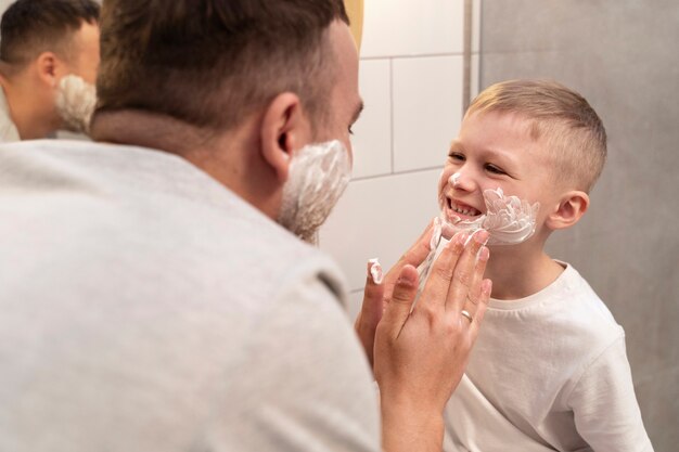 Dad teaching his son how to shave