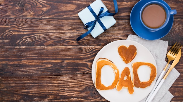 Dad word written in bread buns on wooden board