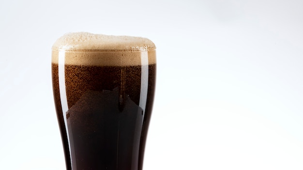 Free photo dark beer with foam closeup