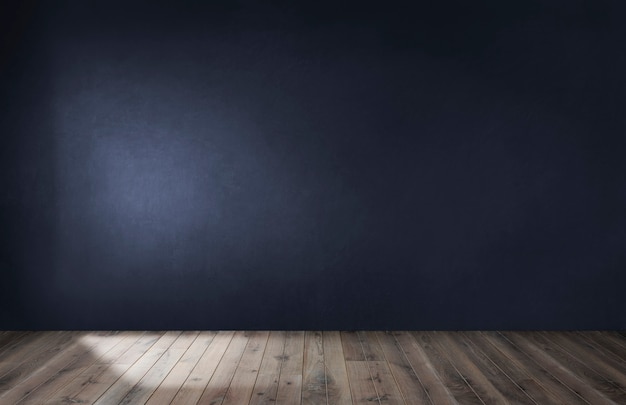 Dark blue wall in an empty room with a wooden floor