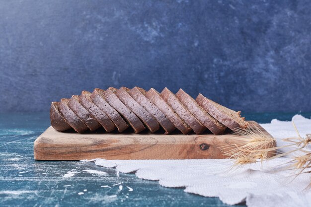 Dark bread slices on blue table.