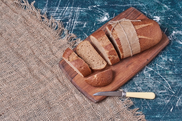 Dark bread slices on wooden board.