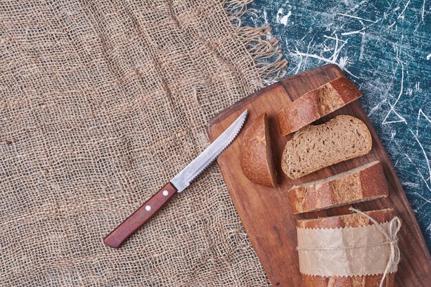 Dark bread slices on wooden board.