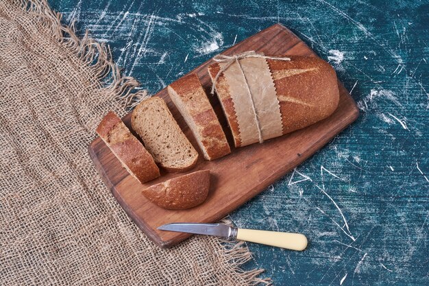 Dark bread on wooden cutting board.