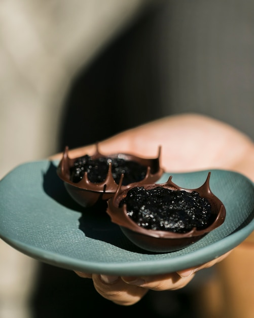 Free photo dark chocolate bowls with filling on plate