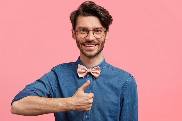 Dark-haired man wearing pink bowtie and denim shirt