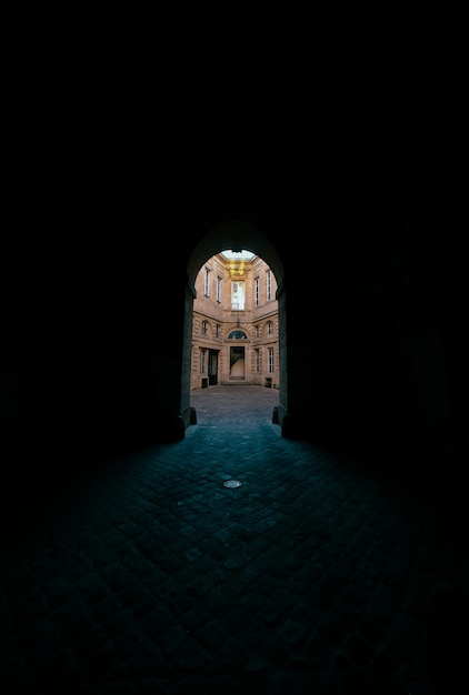 Free photo dark hallway with arched doorway with a view of a concrete building