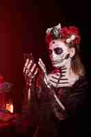 Free photo dark lady blowing kisses during dia de los muertos wearing la catrina costume