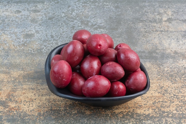 A dark plate of delicious fruits on white background. High quality photo