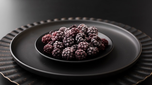 Free photo dark plate with blackberries on a dark table