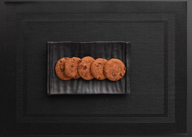 Free photo dark plate with cookies on a dark cloth