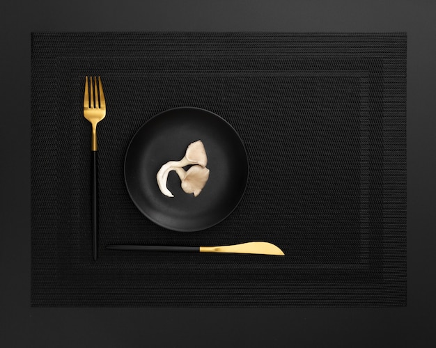 Free Photo dark plate with mushroom on a dark cloth with knife and fork