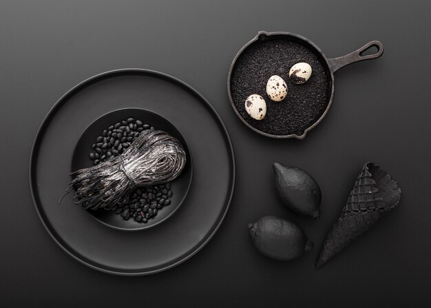 Free photo dark plates with pasta and eggs with beans on a dark background